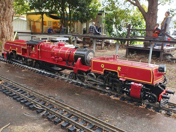a photo of a large red model train that runs on coal steam power